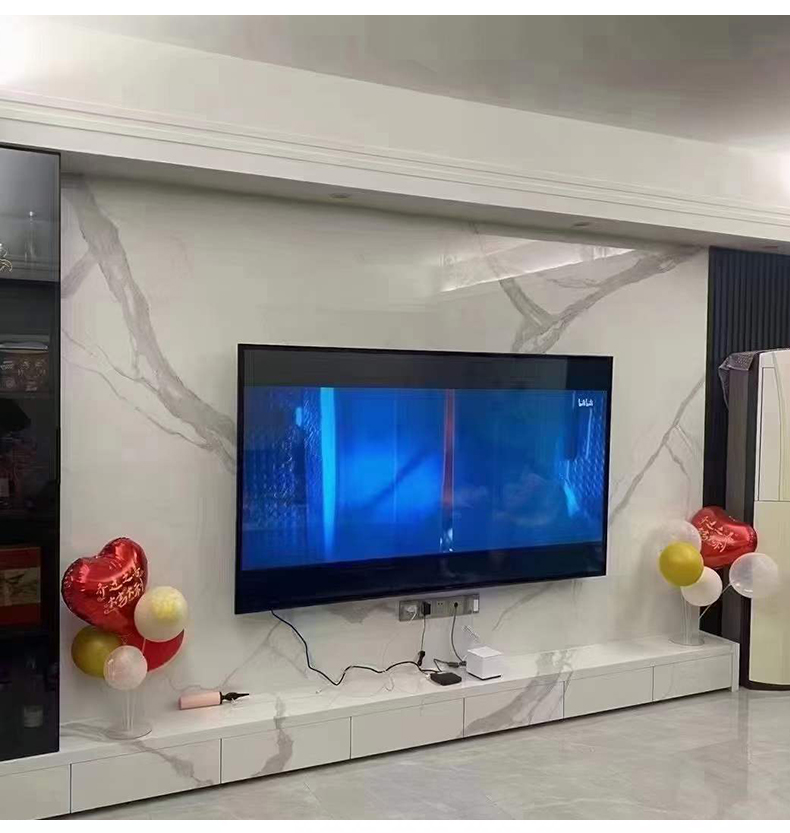 Living room TV wall finished in white and grey marble-effect wall panels above a matching media unit